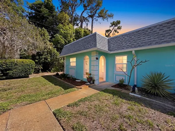 a front view of house with yard and trees around