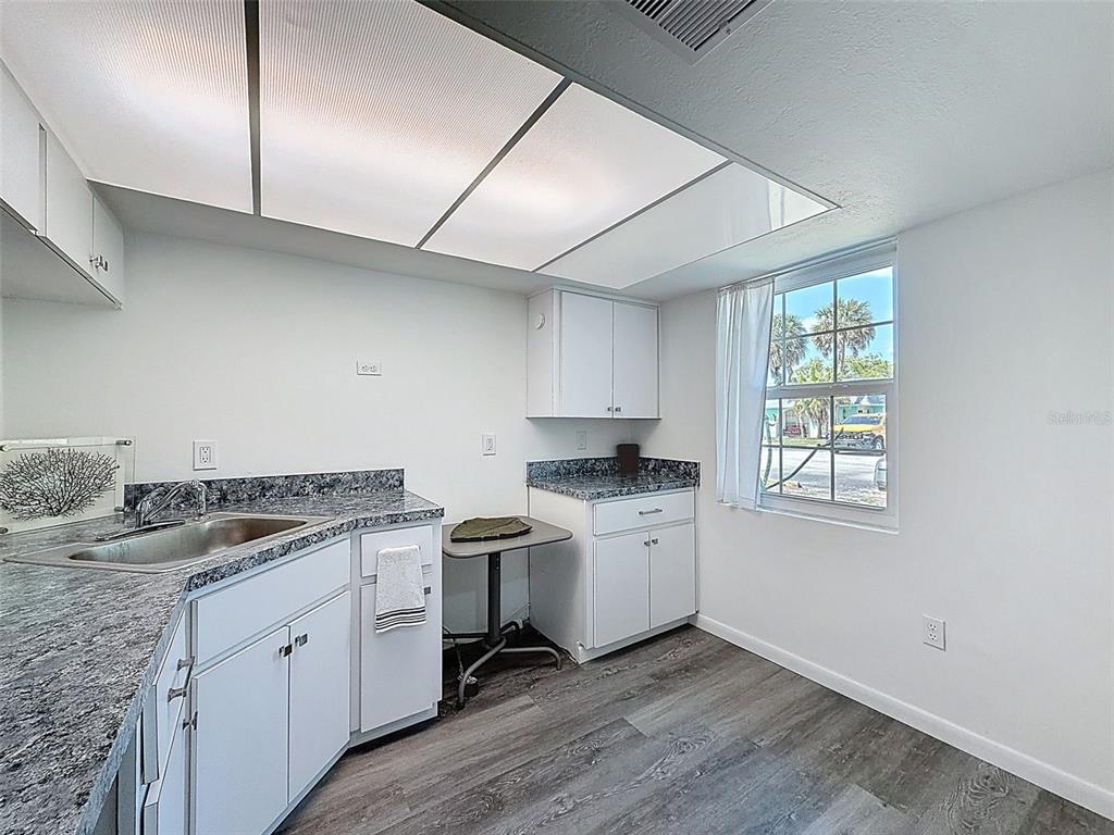 4224 Terrapin Place, Unit 4224 New Port Richey, FL 34652 - Photo 16 of 58 a kitchen with stainless steel appliances granite countertop a stove a sink and white cabinets with wooden floor