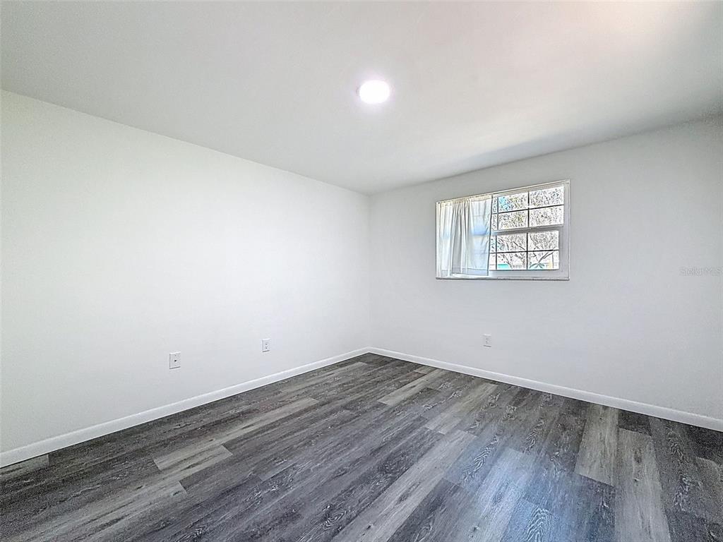 4224 Terrapin Place, Unit 4224 New Port Richey, FL 34652 - Photo 27 of 58 an empty room with wooden floor and windows