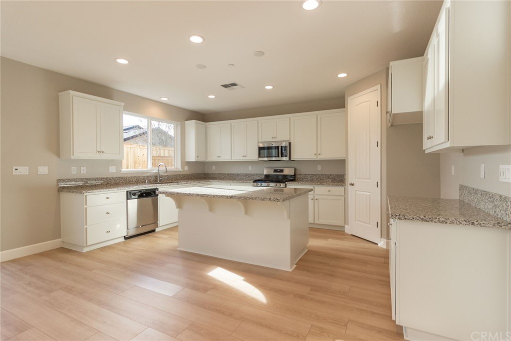 63 Bentwater Loop Chico, CA 95973 - Photo 5 of 20 a kitchen with granite countertop white cabinets and white appliances