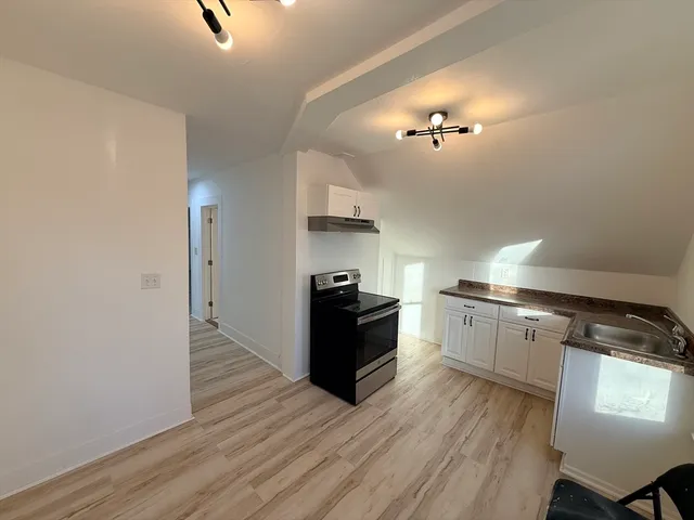 a kitchen with a refrigerator and a stove top oven