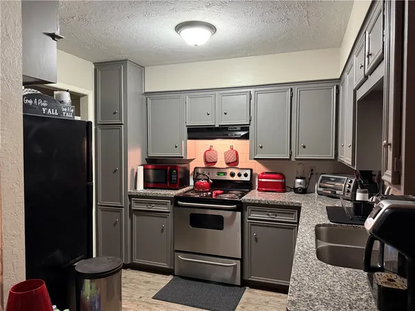 a kitchen with stainless steel appliances a stove a refrigerator and a cabinets