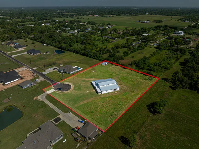 an aerial view of a houses with a yard