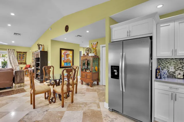 a kitchen with stainless steel appliances refrigerator dining table and chairs