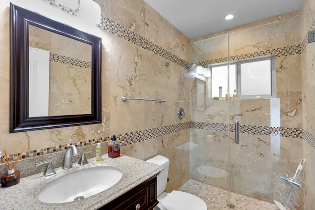 a bathroom with a sink shower and a mirror