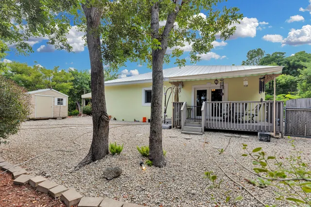 a view of a porch with a tree and wooden fence