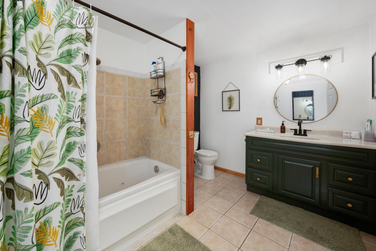 85-4563 Hawaii Belt Road Captain Cook, HI 96704 - Photo 24 of 30 a bathroom with a tub sink and mirror