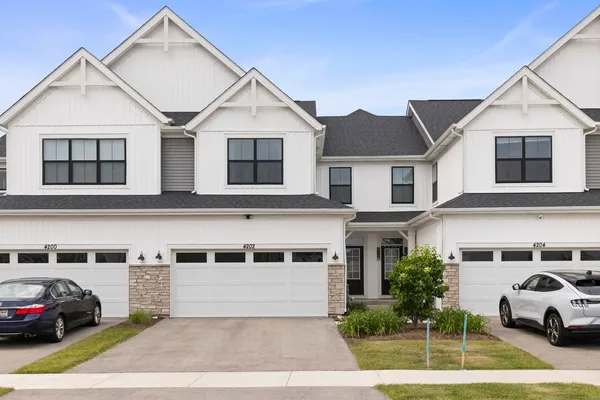 a view of a white house with a large windows and a yard