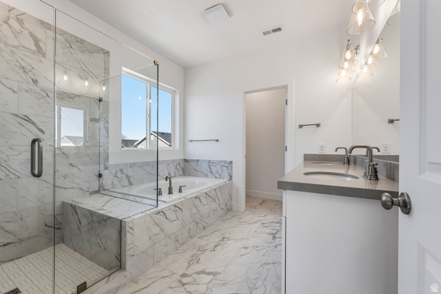 58 South Crimson Way, Unit 306 Mapleton, UT 84664 - Photo 21 of 24 Bathroom featuring a large soaker tub, glass-enclosed shower with tile surround, dual vanity with undermount sinks, and contemporary light fixtures
