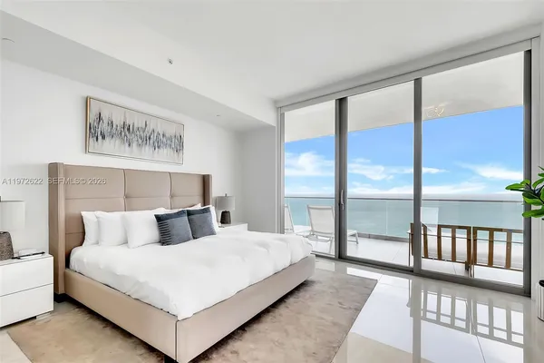 a spacious bedroom with a large bed and a large window