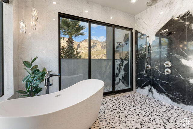 3652 South Cypress Road Hurricane, UT 84737 - Photo 45 of 81 Freestanding soaking tub, floor-to-ceiling black-framed sliding glass doors, dual shower system with polished chrome fixtures, black and white marble shower surround, and mosaic pebble floor