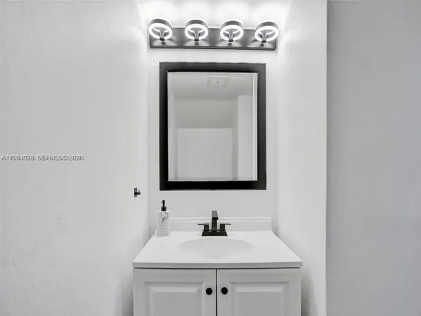 a bathroom with a sink a mirror and vanity