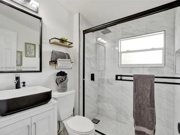 a bathroom with a sink a toilet and shower