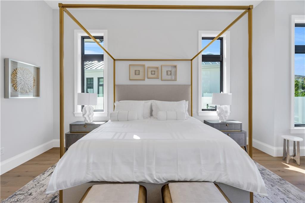 635 Harbour Drive Naples, FL 34103 - Photo 13 of 32 a bedroom with a large bed and a painting on the wall