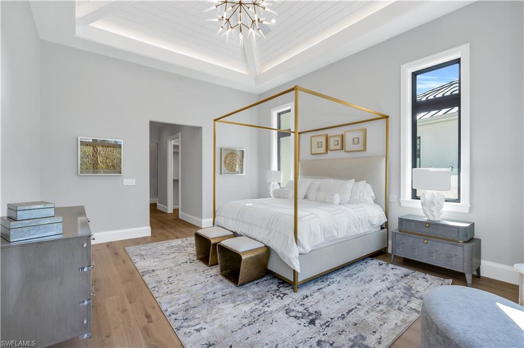 635 Harbour Drive Naples, FL 34103 - Photo 14 of 32 a bedroom with a bed and a chandelier