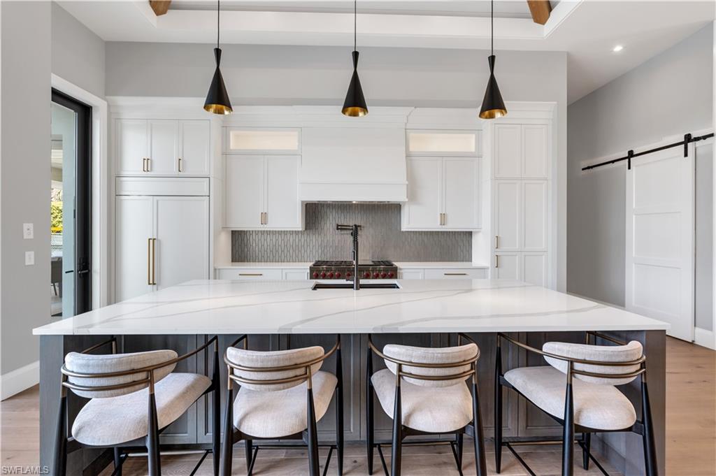 635 Harbour Drive Naples, FL 34103 - Photo 7 of 32 a kitchen with stainless steel appliances granite countertop a table chairs stove and refrigerator