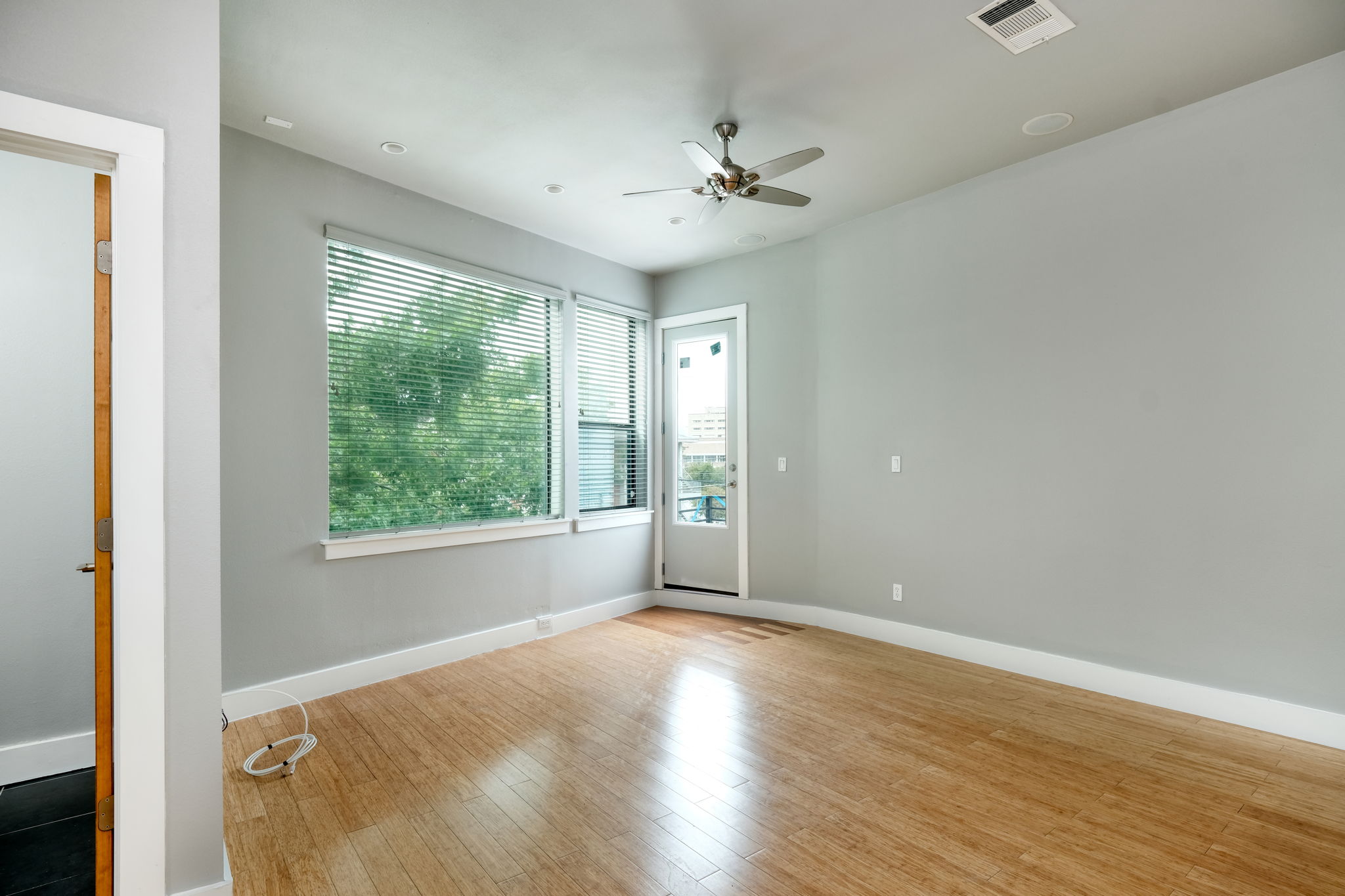 3000 Speedway Street, Unit E Austin, TX 78705 - Photo 4 of 16 A versatile living space with light-colored flooring, generous window light, and access to an outdoor area.
