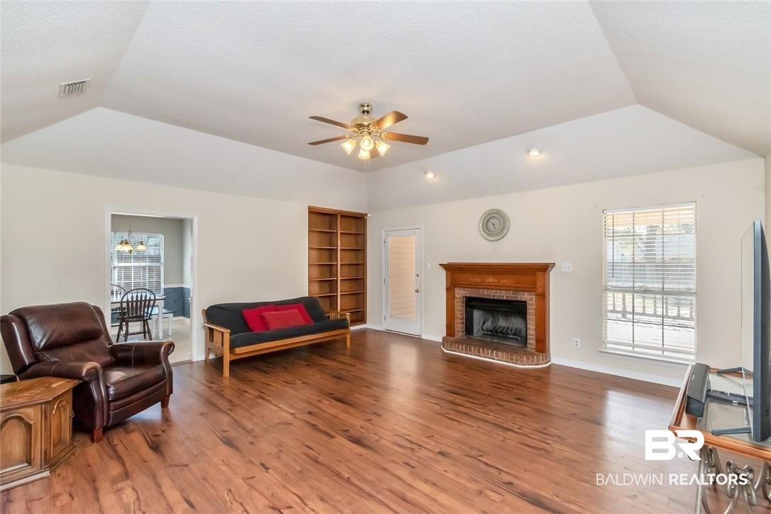 6601 Conde Court Mobile, AL 36695 - Photo 7 of 30 Living room with ceiling fan, wood-type flooring, a brick fireplace, and lofted ceiling
