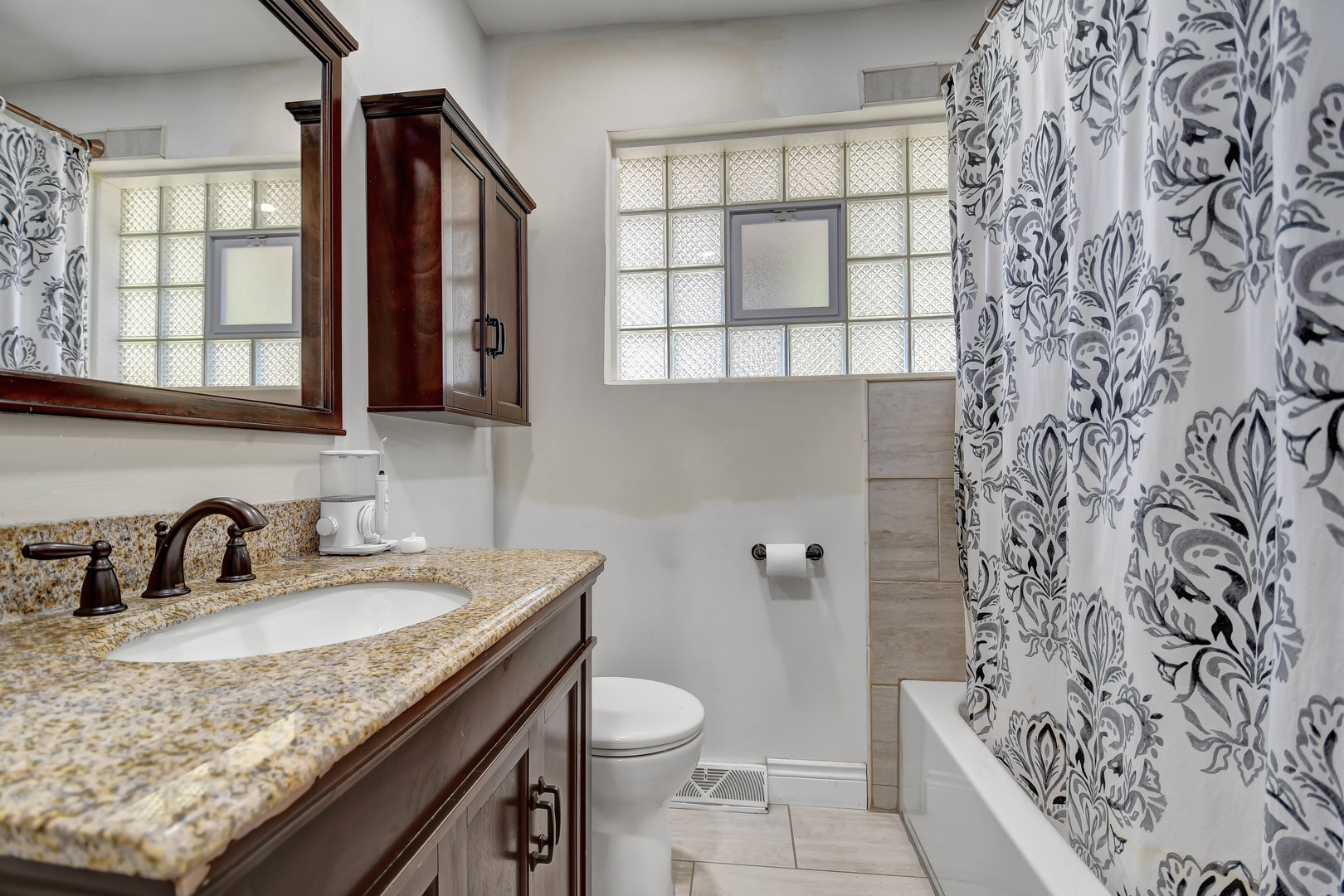 5700 South Monitor Avenue Chicago, IL 60638 - Photo 12 of 22 a bathroom with a granite countertop sink a toilet and shower