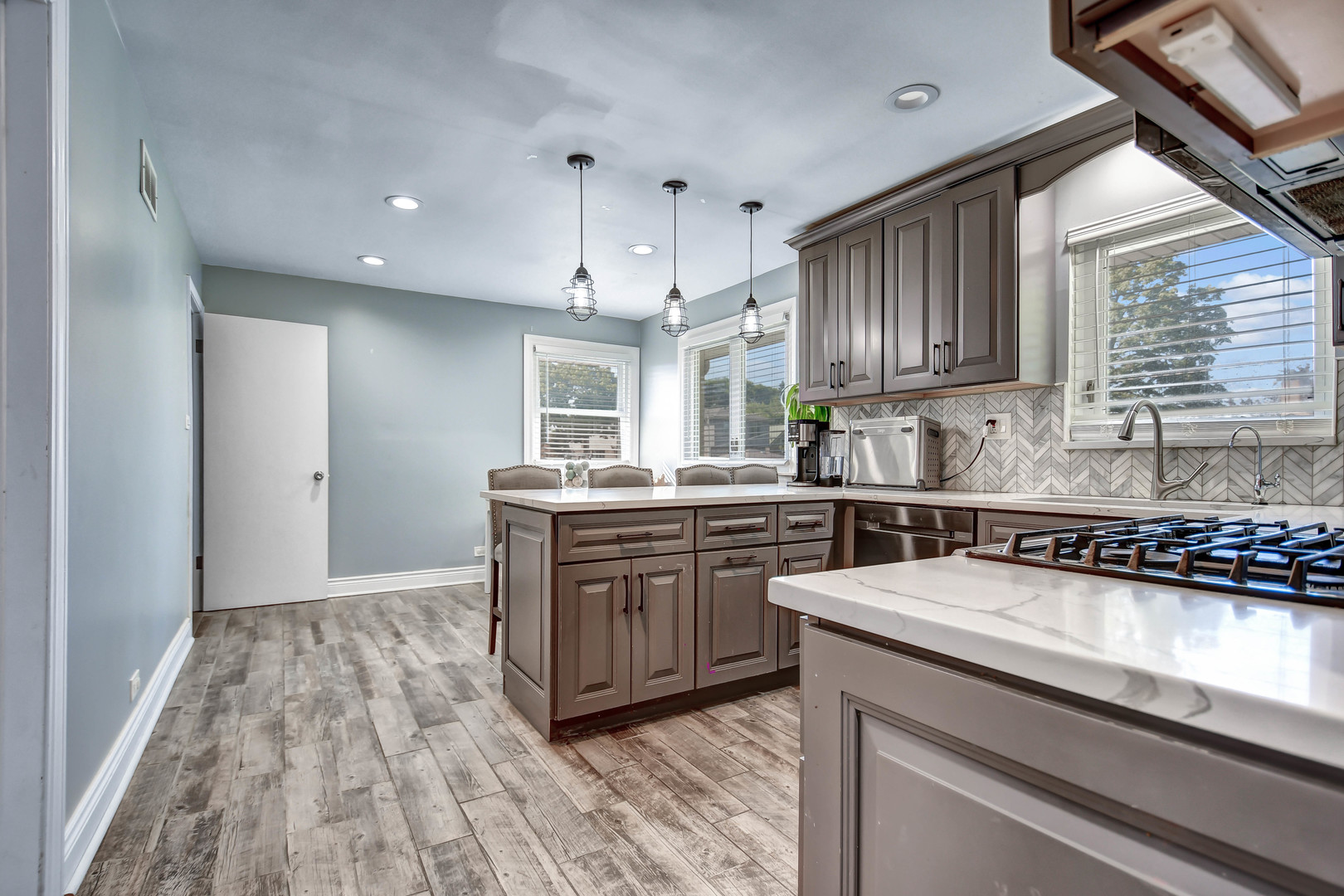 5700 South Monitor Avenue Chicago, IL 60638 - Photo 7 of 22 a kitchen with granite countertop wooden cabinets a sink dishwasher and a stove with wooden floor