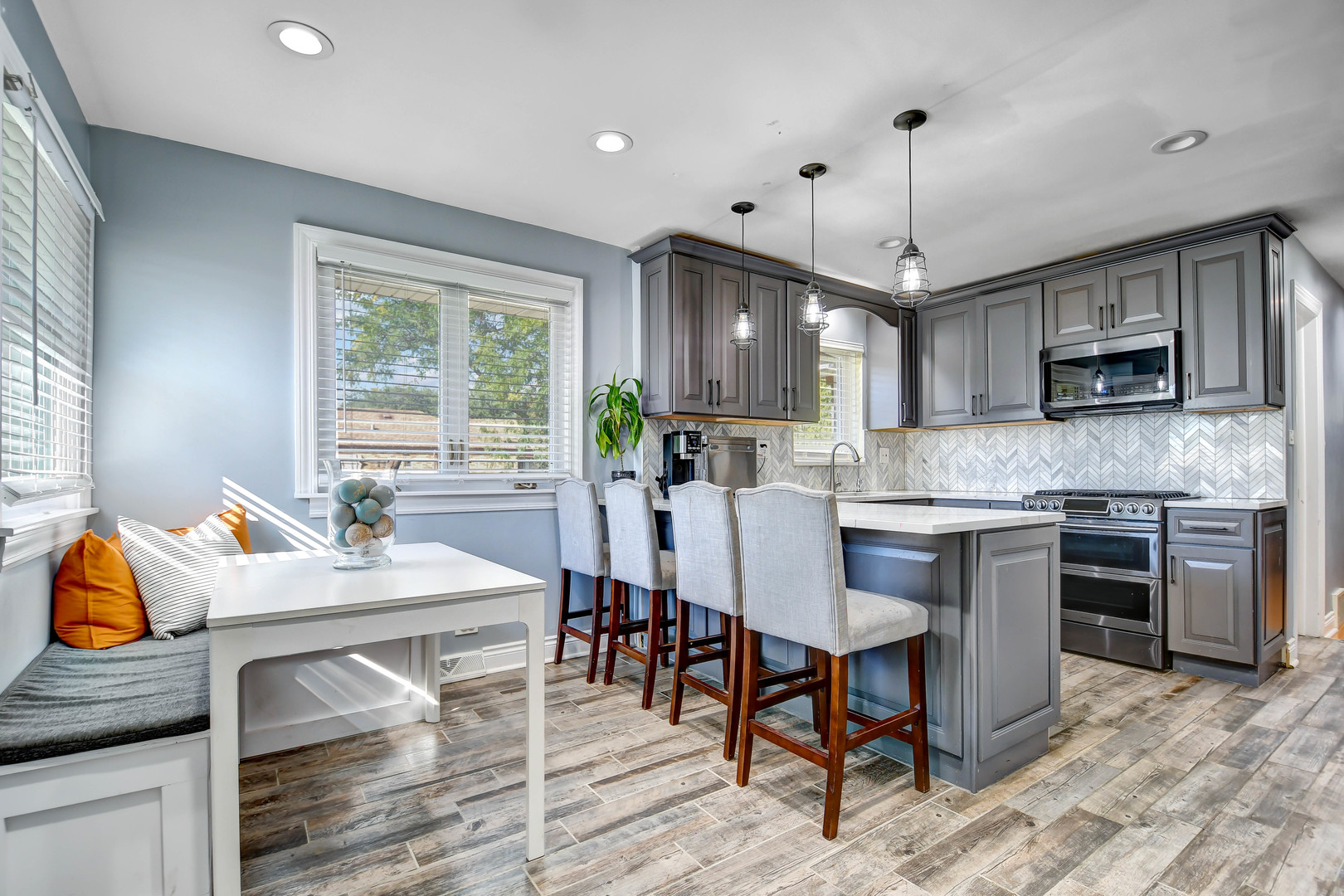 5700 South Monitor Avenue Chicago, IL 60638 - Photo 8 of 22 a kitchen with kitchen island granite countertop a stove a sink a dining table and chairs with wooden floor