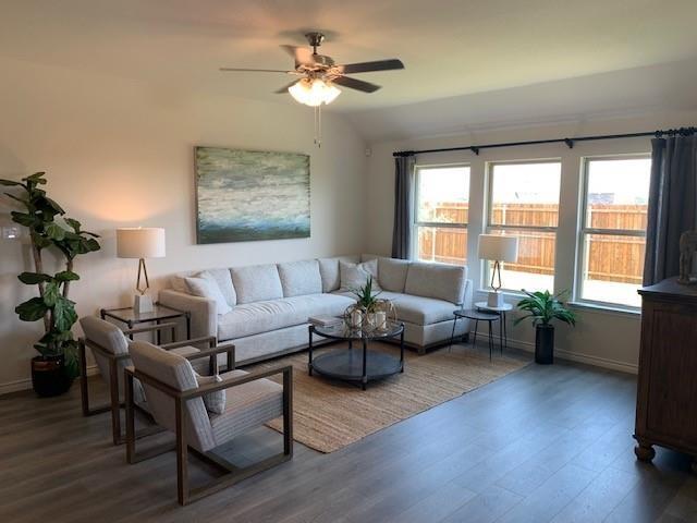 712 Feldspar Way Princeton, TX 75407 - Photo 9 of 12 Spacious living area featuring wood-finish flooring, a ceiling fan, and large windows with privacy fencing visible beyond