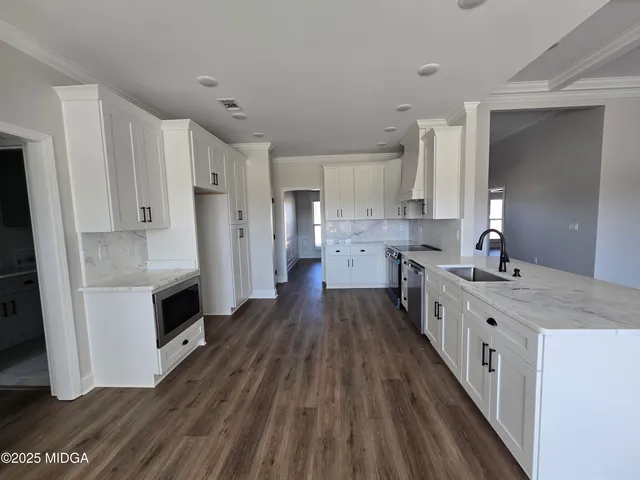 a large kitchen with a lot of counter space and stainless steel appliances