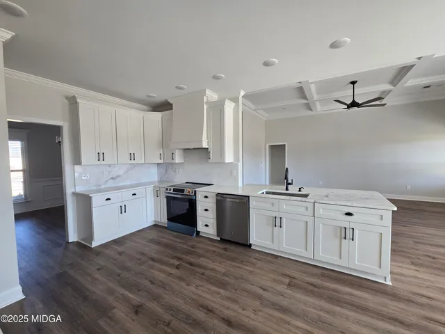 a kitchen with stainless steel appliances sink a stove and cabinets