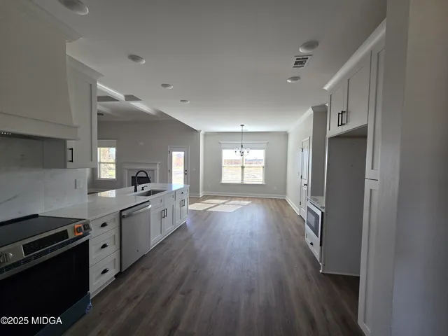 a large kitchen with a wooden floor and stainless steel appliances