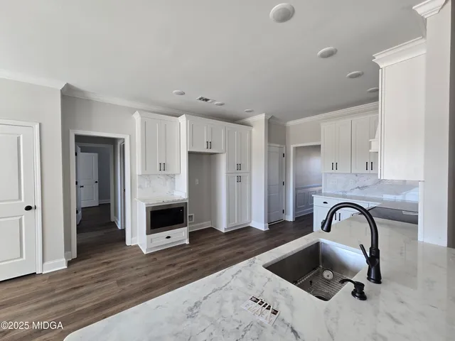 a view of a kitchen with a sink and refrigerator