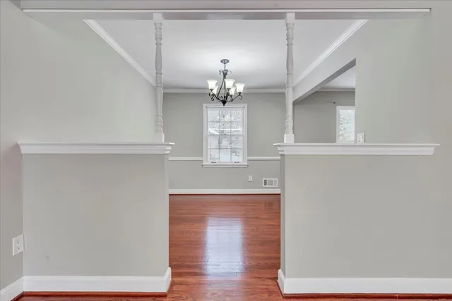 a kitchen with a refrigerator and countertop white cabinets with wooden floor