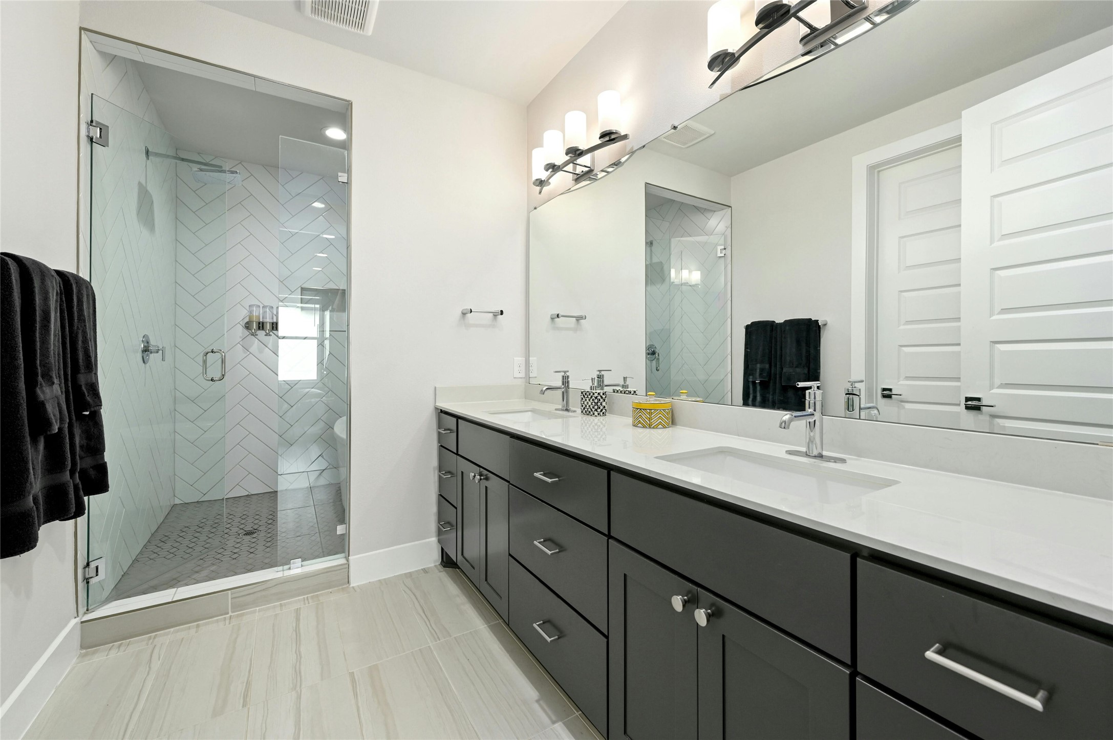 4604 Longevity Drive, Unit 306 Austin, TX 78731 - Photo 18 of 34 a bathroom with a double vanity sink a large mirror and shower