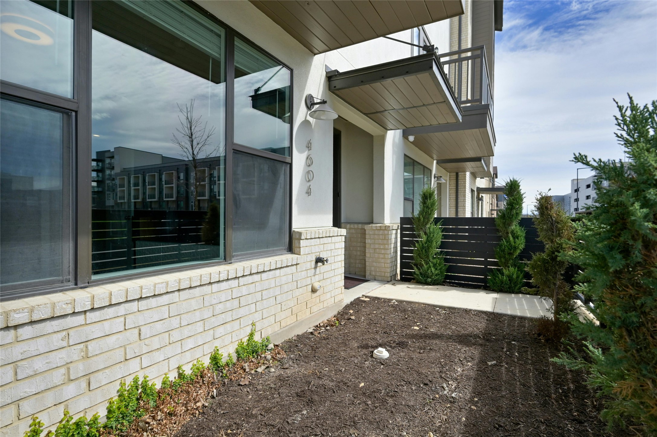 4604 Longevity Drive, Unit 306 Austin, TX 78731 - Photo 2 of 34 a view of a pathway that has a large window and potted plants