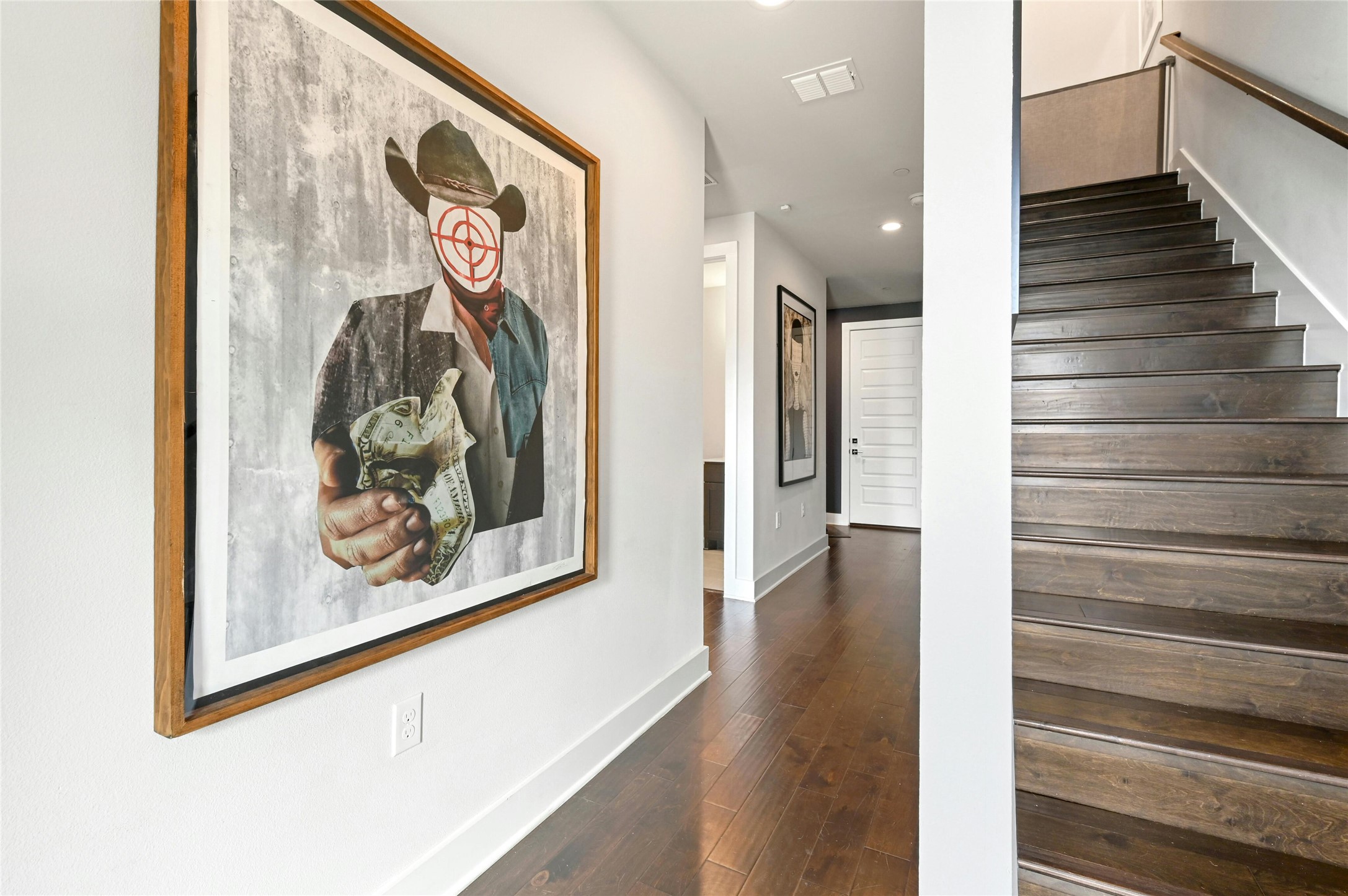 4604 Longevity Drive, Unit 306 Austin, TX 78731 - Photo 4 of 34 a view of a hallway with wooden floor and paintings on the wall