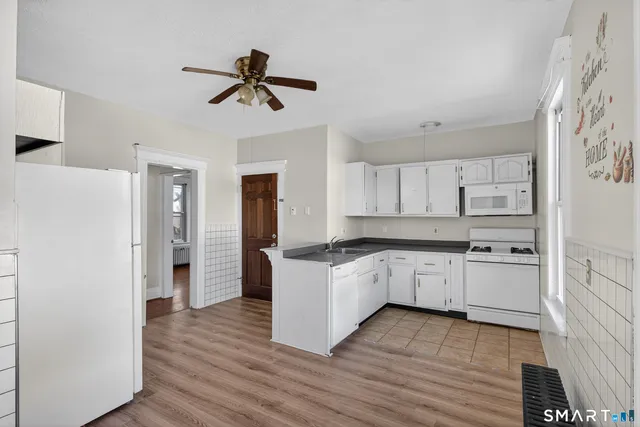 a kitchen with granite countertop a refrigerator and a stove top oven