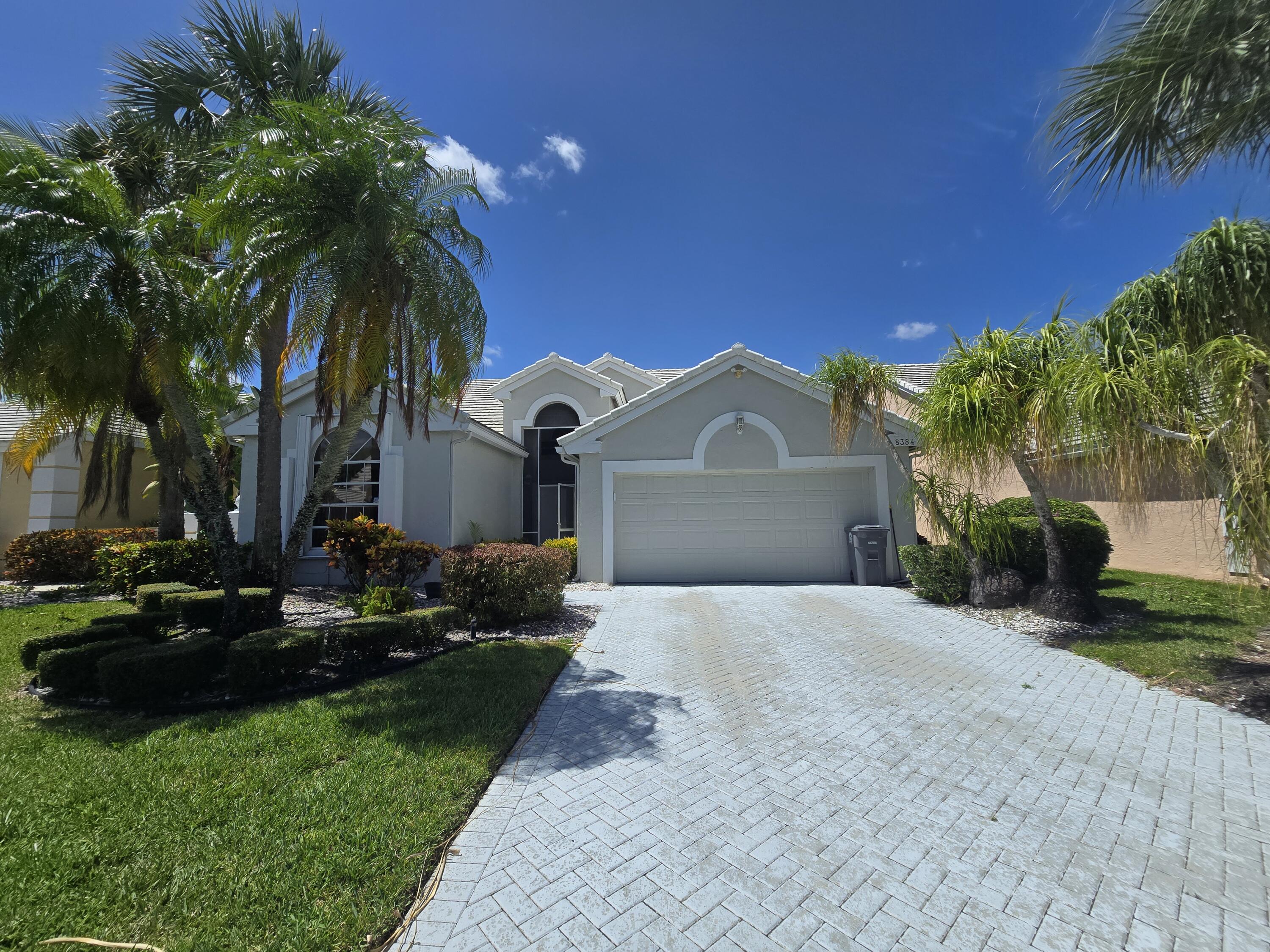 8384 Horseshoe Bay Road Boynton Beach, FL 33472 - Photo 1 of 33 a front view of a house with a garden and yard