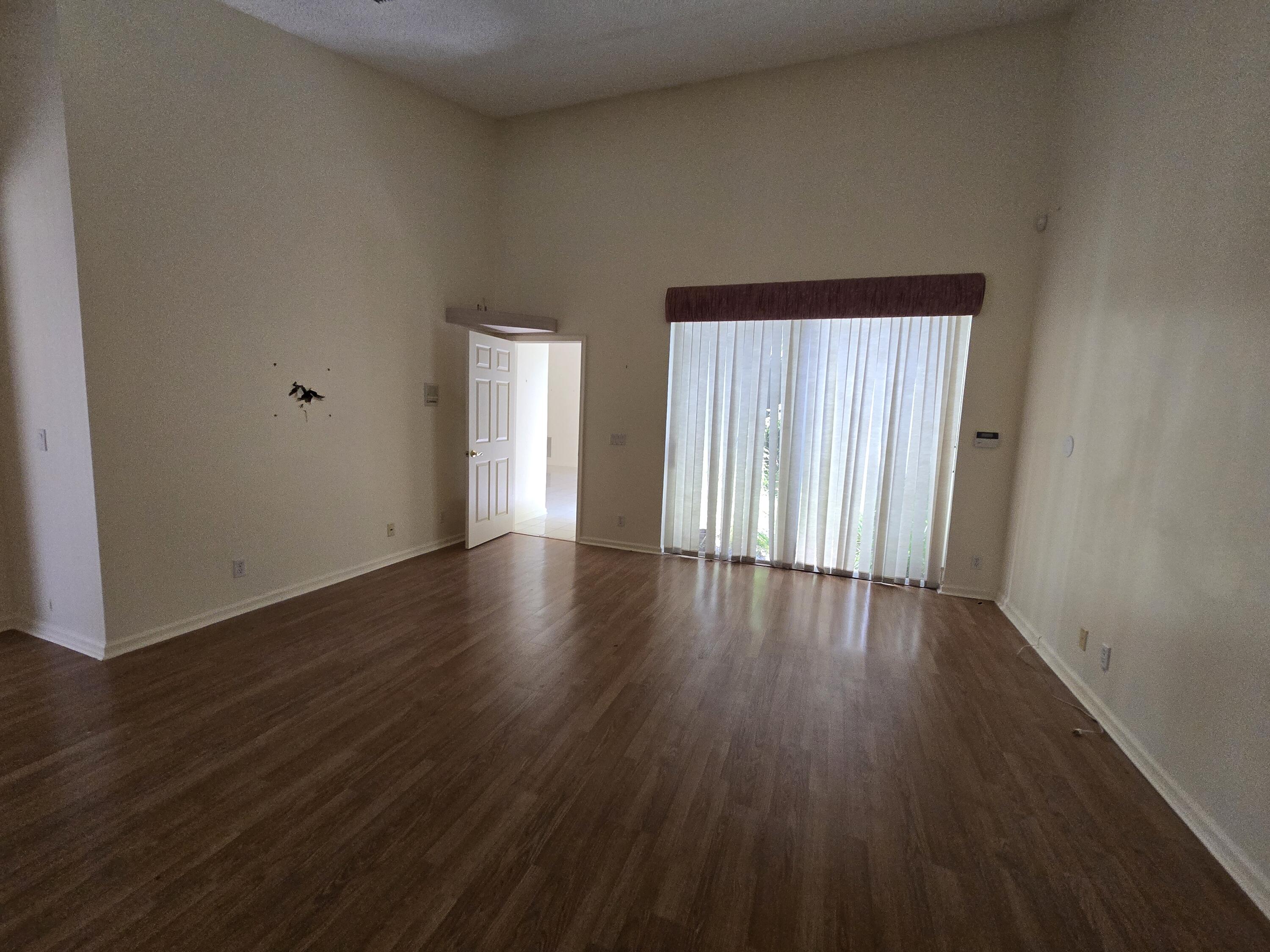 8384 Horseshoe Bay Road Boynton Beach, FL 33472 - Photo 25 of 33 a view of an empty room with wooden floor and a window