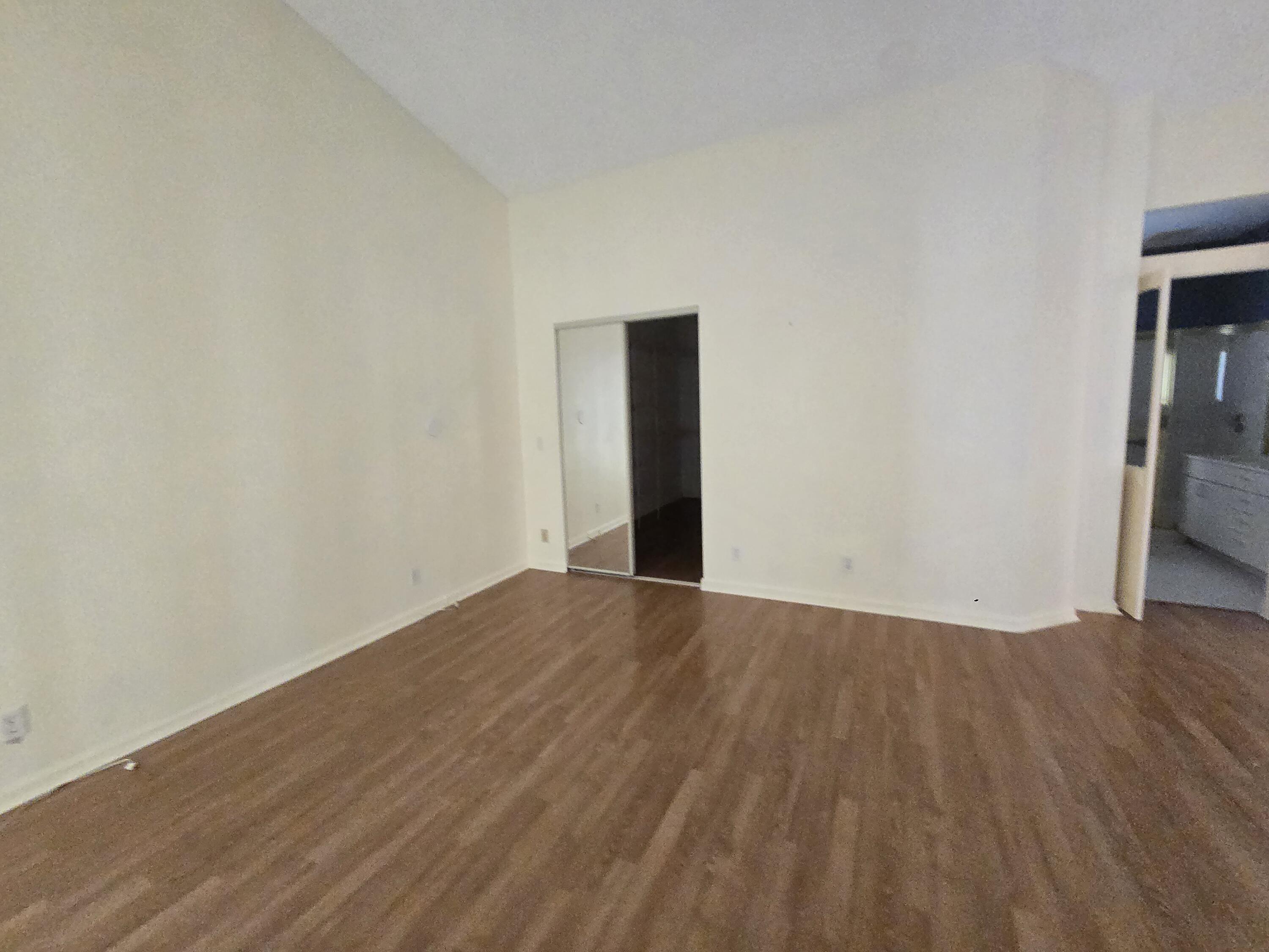 8384 Horseshoe Bay Road Boynton Beach, FL 33472 - Photo 26 of 33 a view of an empty room with wooden floor and a window