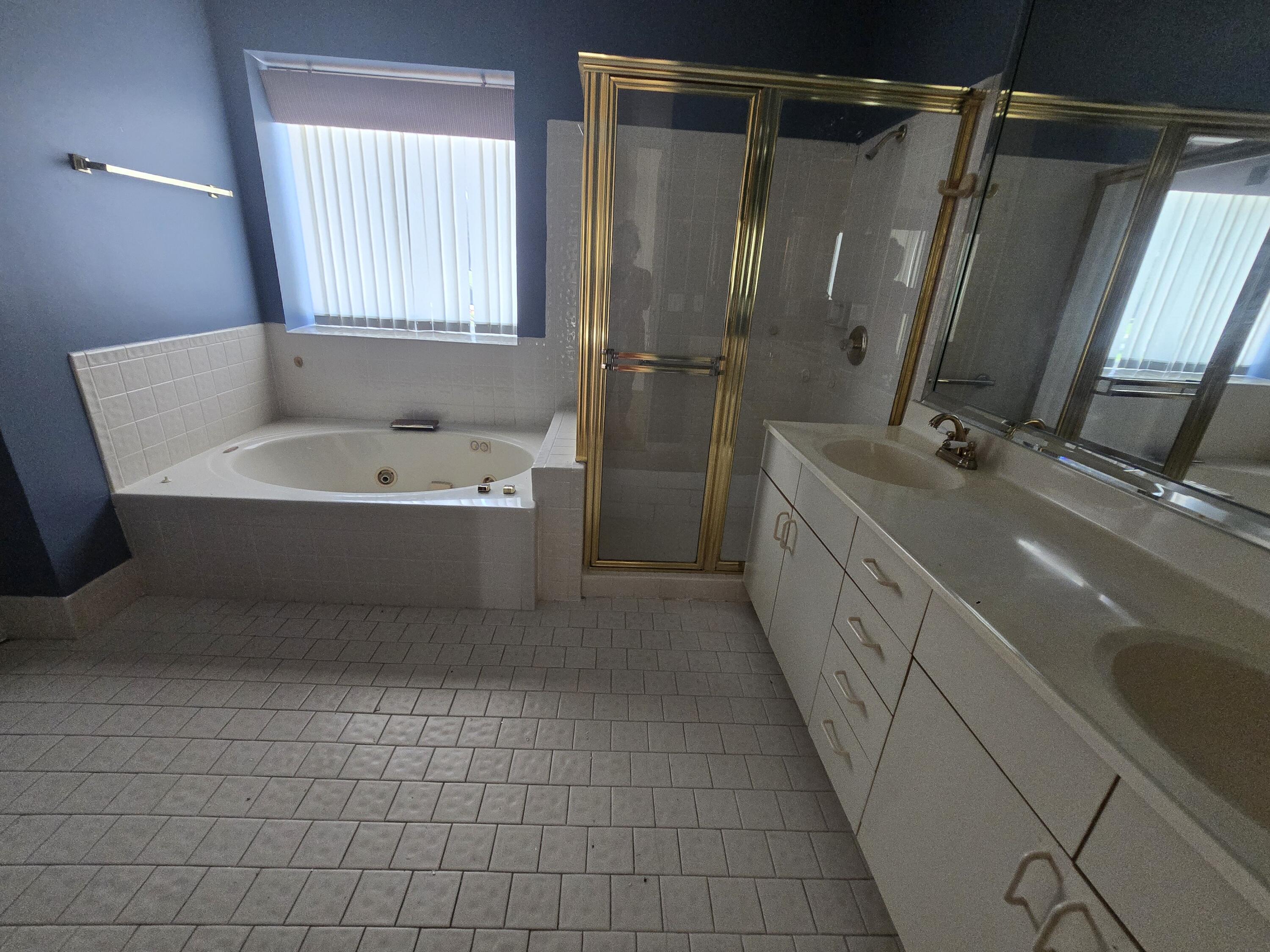 8384 Horseshoe Bay Road Boynton Beach, FL 33472 - Photo 29 of 33 a bathroom with a tub a sink a mirror and a shower
