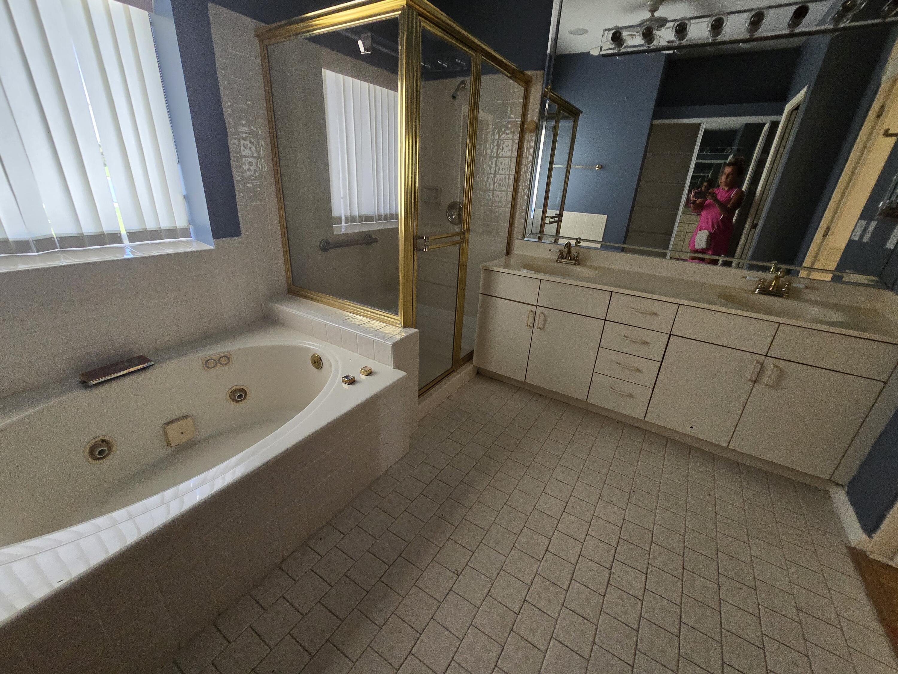 8384 Horseshoe Bay Road Boynton Beach, FL 33472 - Photo 31 of 33 a bathroom with a tub sink and mirror