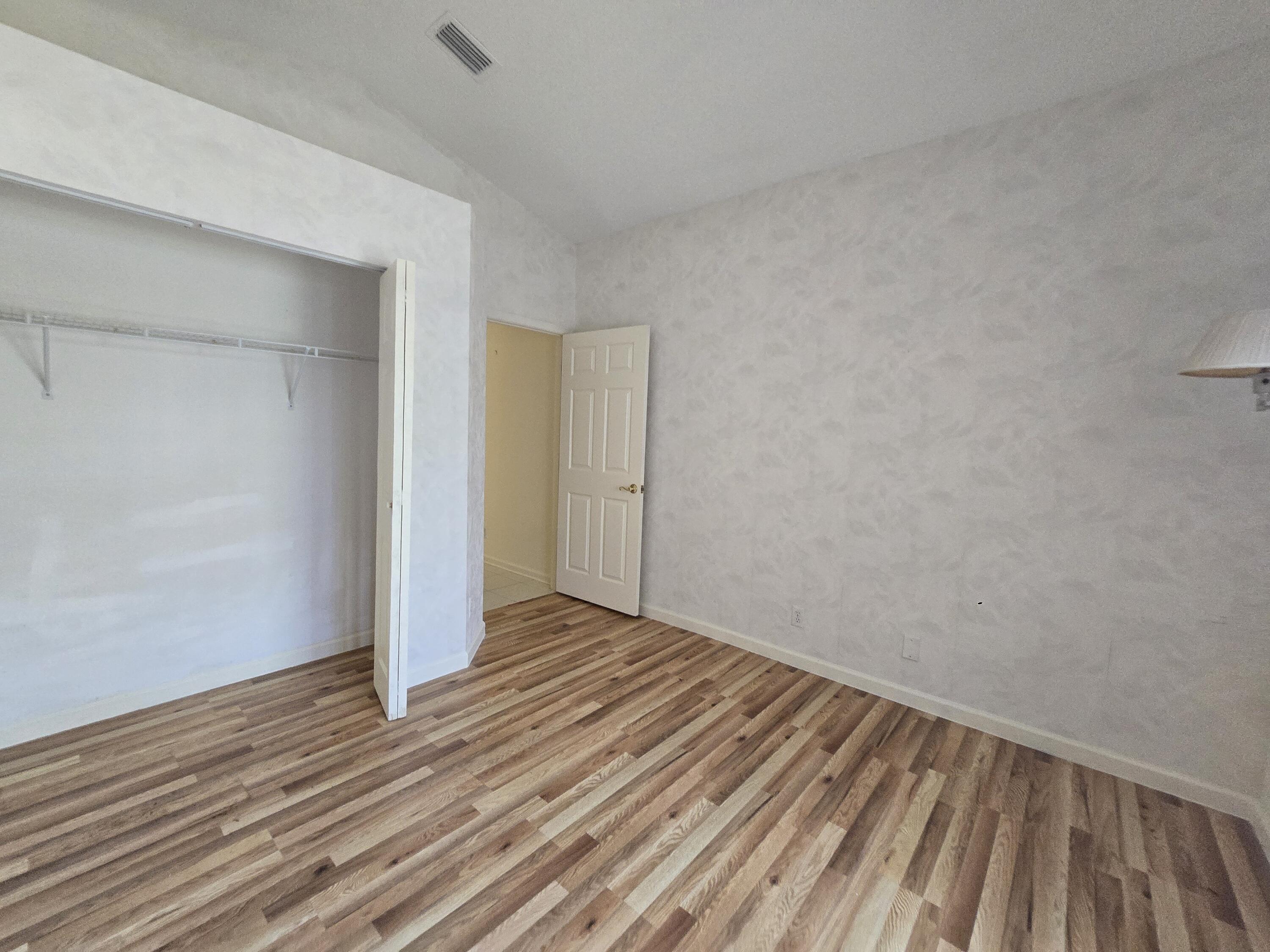 8384 Horseshoe Bay Road Boynton Beach, FL 33472 - Photo 4 of 33 a view of an empty room with wooden floor
