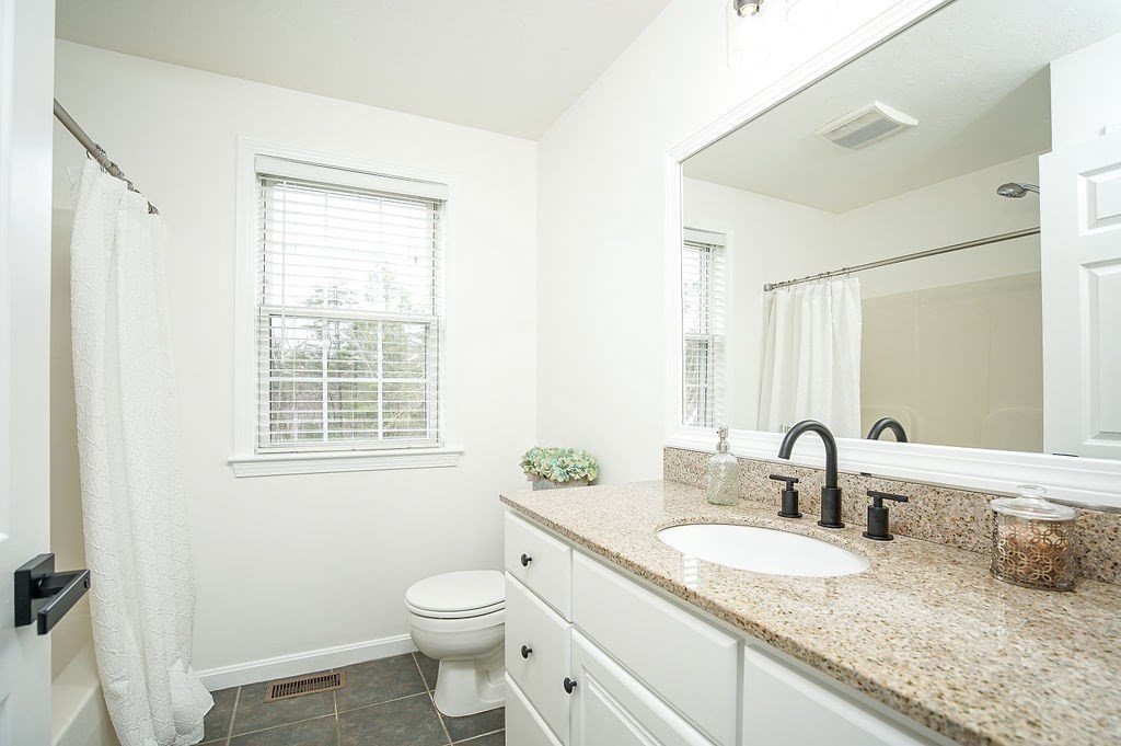 7 Draper Woods Road Sturbridge, MA 01518 - Photo 25 of 38 a bathroom with a granite countertop sink mirror vanity and a toilet