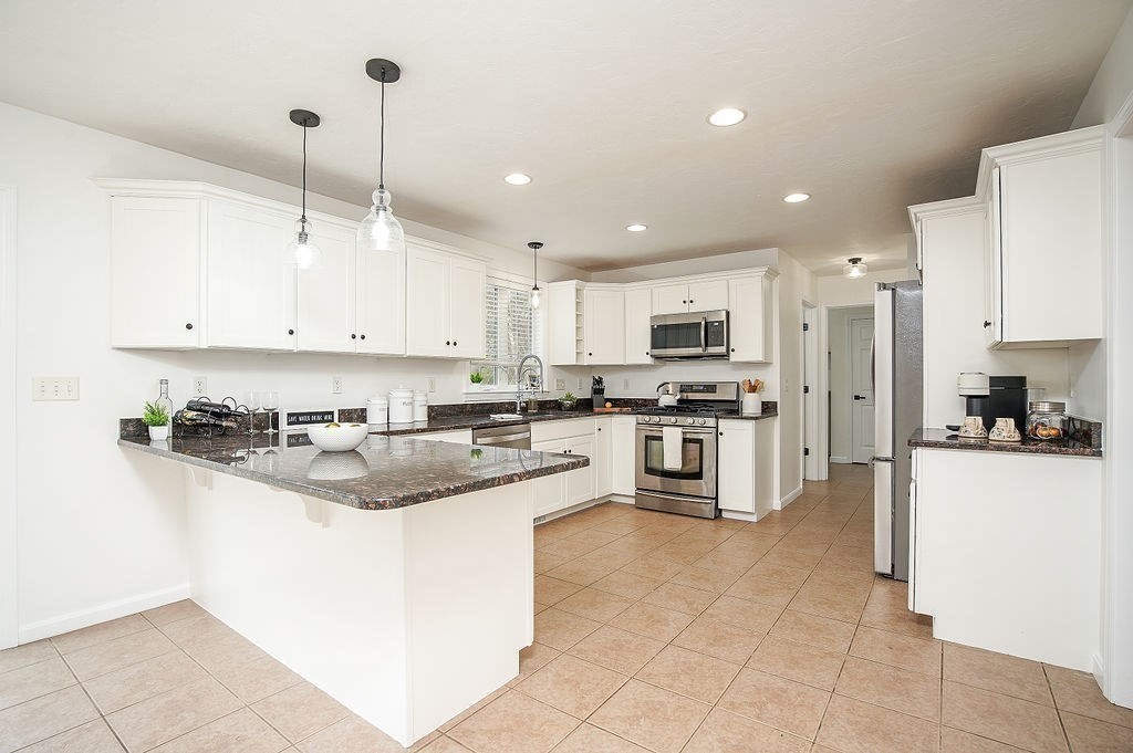 7 Draper Woods Road Sturbridge, MA 01518 - Photo 4 of 38 a kitchen with stainless steel appliances granite countertop a stove top oven a refrigerator a sink and a oven