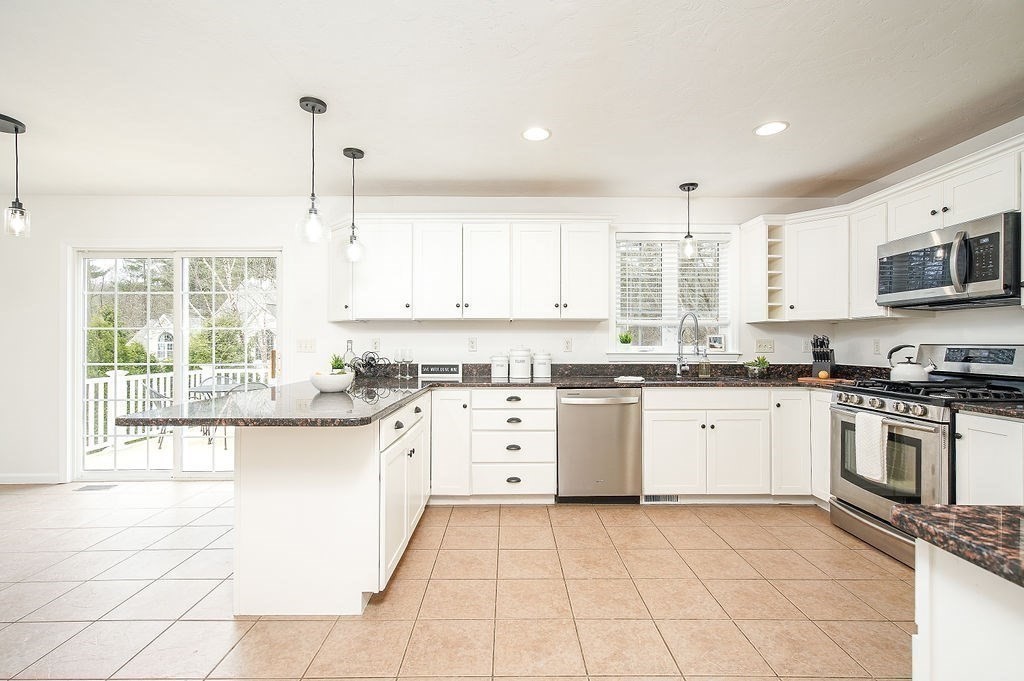 7 Draper Woods Road Sturbridge, MA 01518 - Photo 5 of 38 a kitchen with a sink window and cabinets