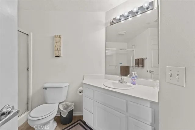 a bathroom with a sink toilet vanity and shower