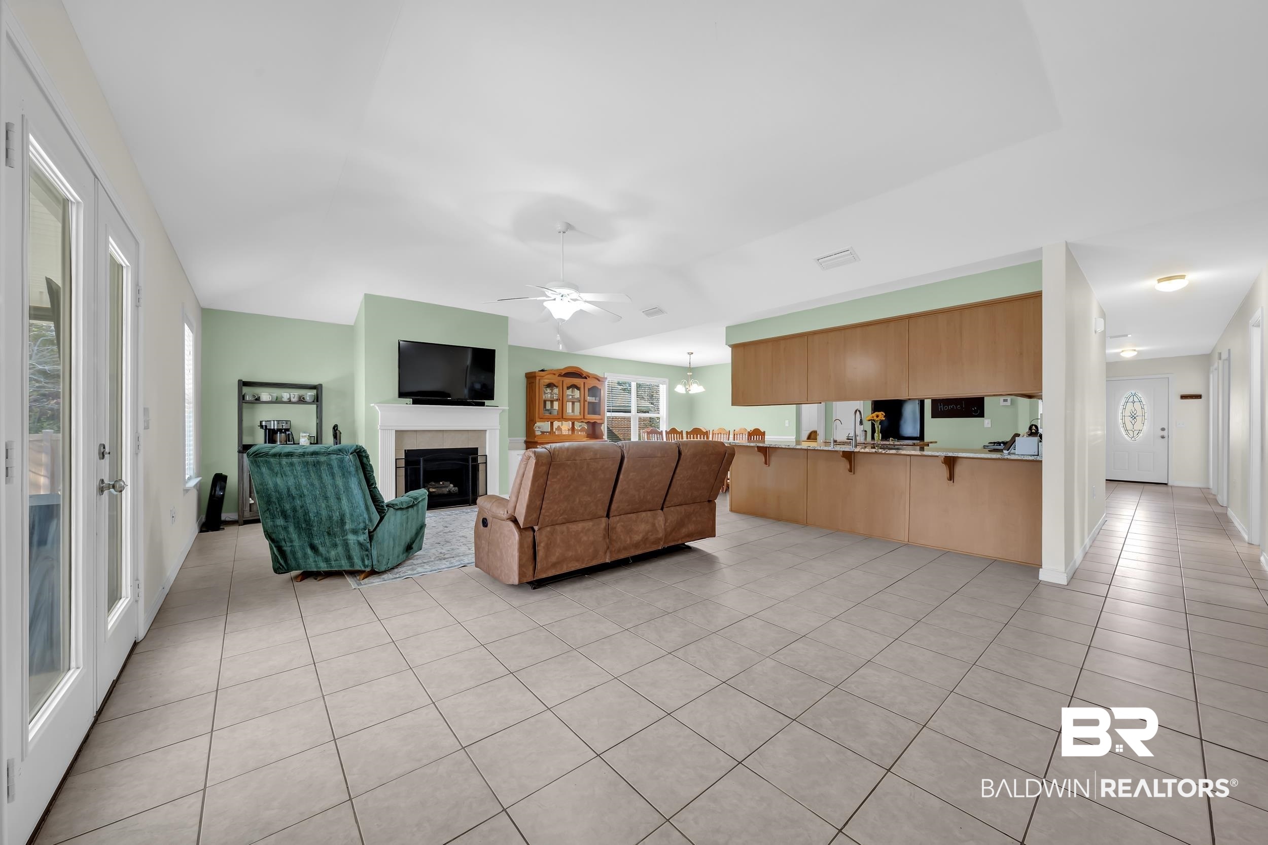 31527 Heidelbrook Loop Daphne, AL 36527 - Photo 5 of 22 Living room with ceiling fan, a tile fireplace, light tile patterned floors, healthy amount of natural light, and lofted ceiling