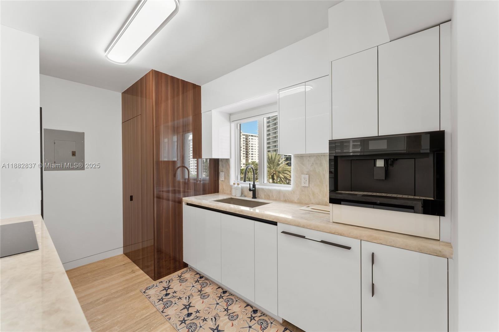 5900 Collins Avenue, Unit 604 Miami Beach, FL 33140 - Photo 18 of 30 a kitchen with stainless steel appliances granite countertop a sink and a microwave