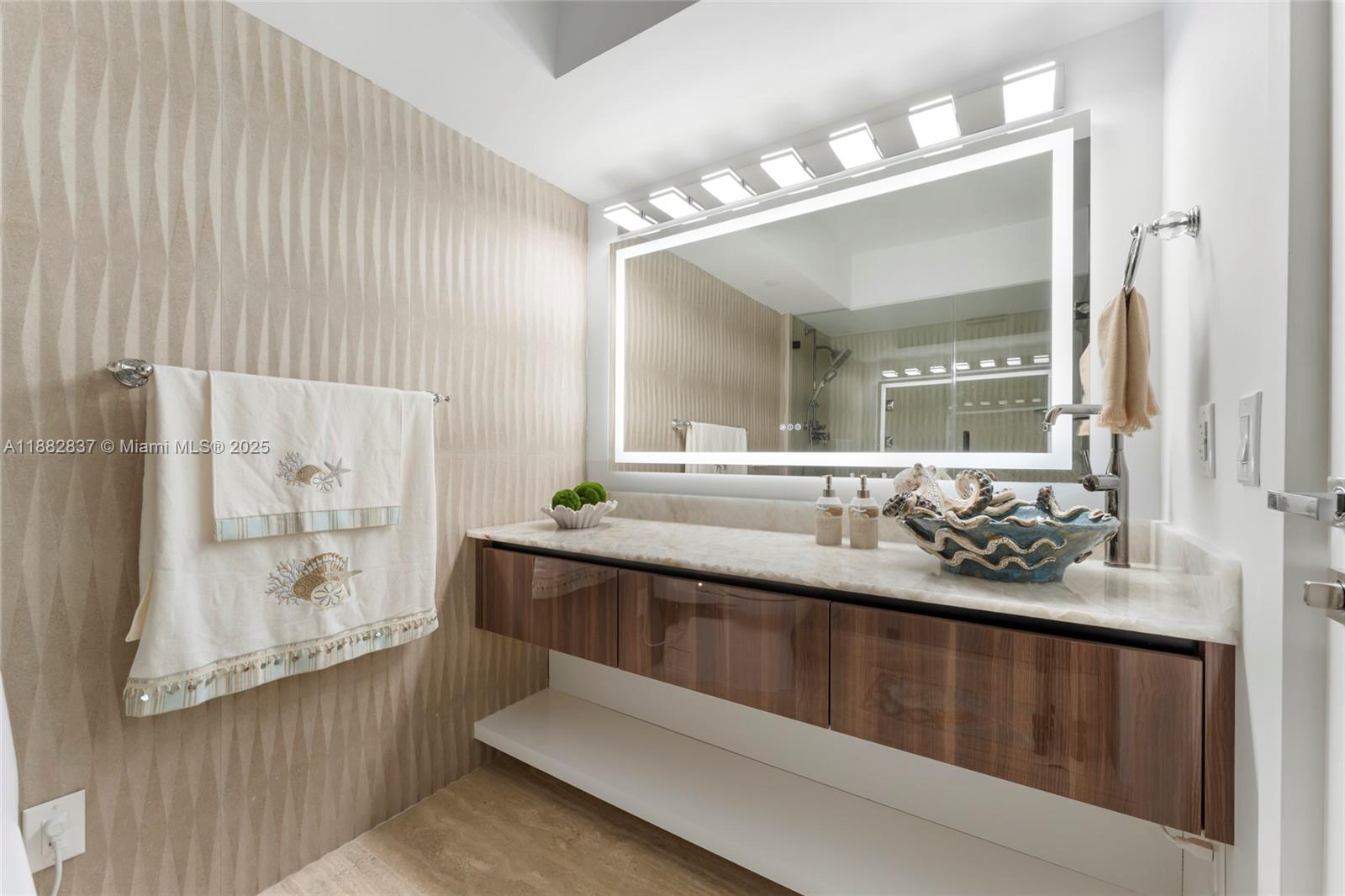 5900 Collins Avenue, Unit 604 Miami Beach, FL 33140 - Photo 23 of 30 a bathroom with a sink a large mirror and a bathtub
