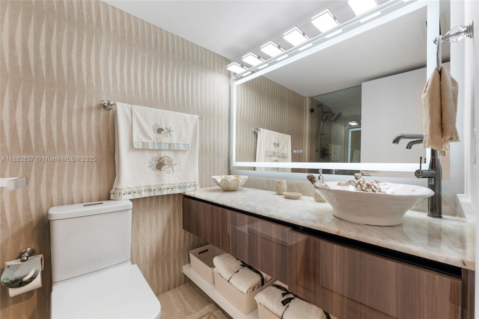 5900 Collins Avenue, Unit 604 Miami Beach, FL 33140 - Photo 29 of 30 a bathroom with a granite countertop sink a toilet a mirror and shower