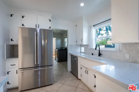 a kitchen with stainless steel appliances a refrigerator sink and microwave